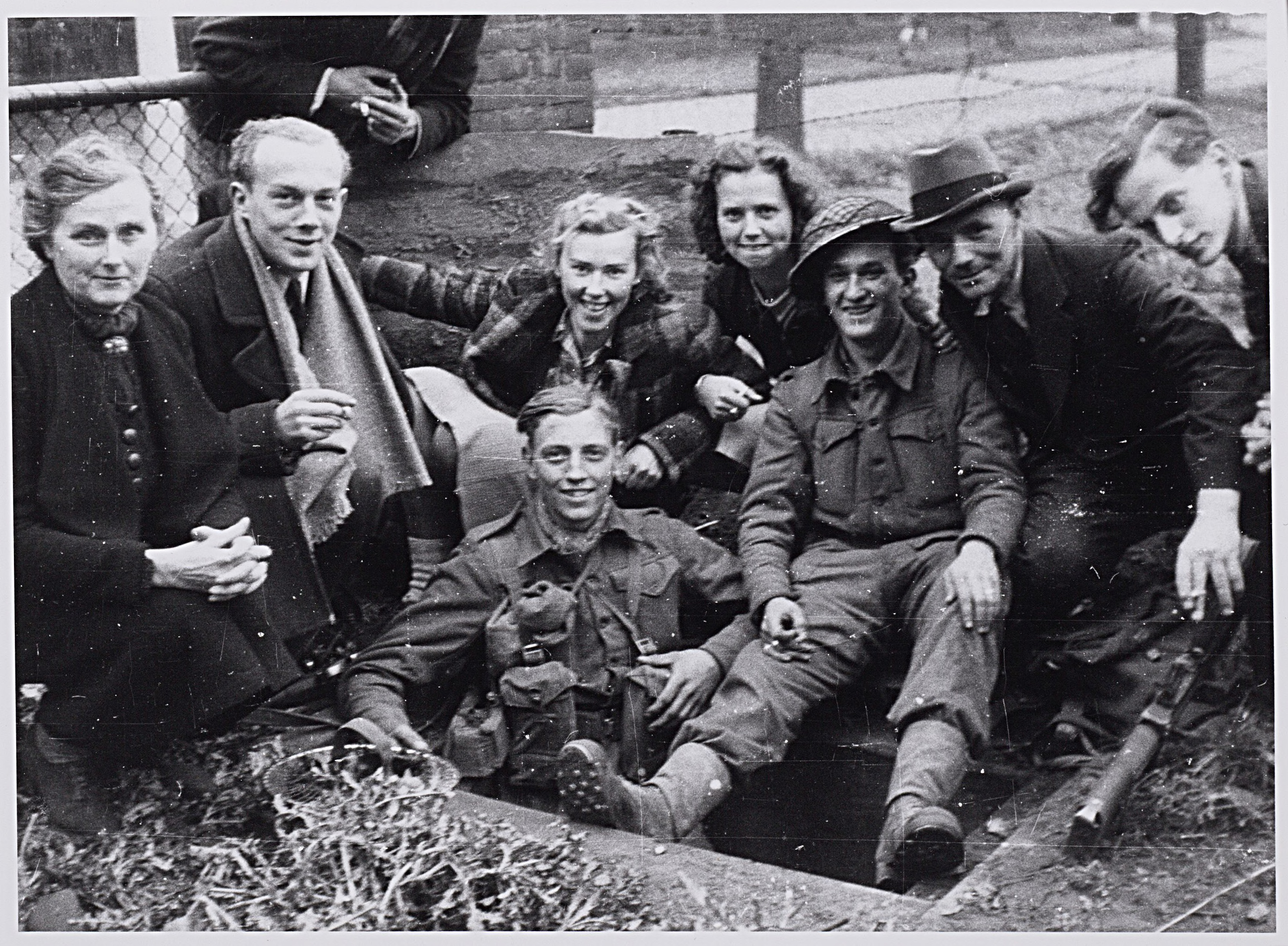 Bevrijding. Enkele Schotse Cameronians in hun schuttersputje in de Enschotsestraat krijgen bezoek van enkele blije buurtbewoners. Collectie Regionaal Archief Tilburg