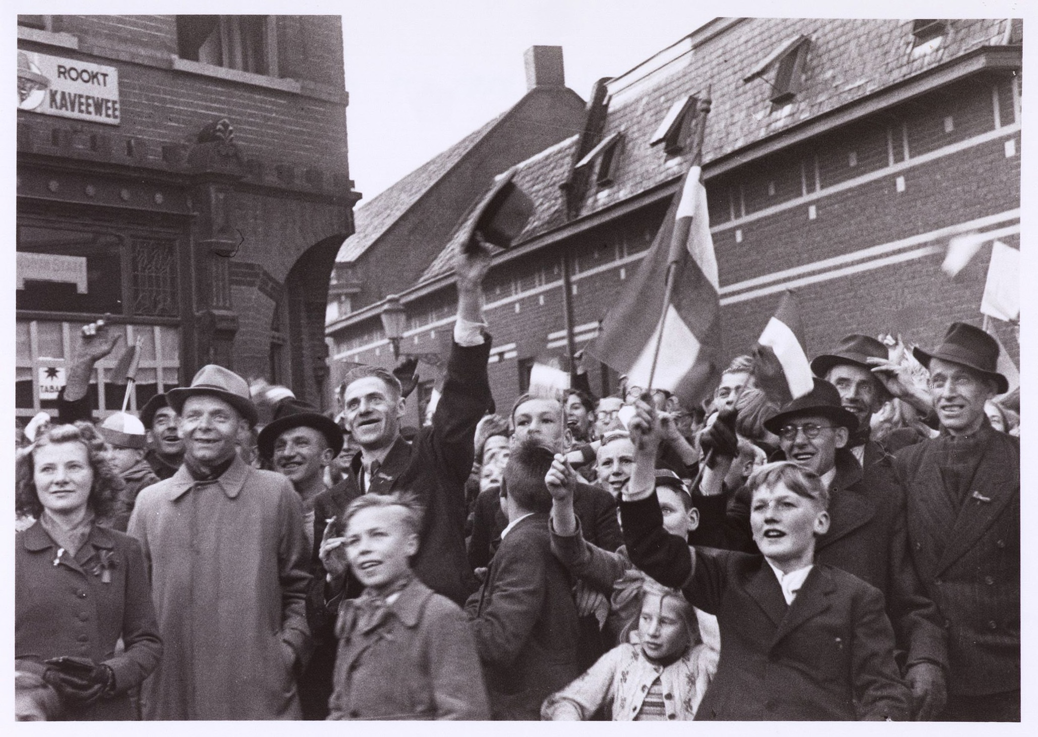 Bevrijding. Getooid met Nederlandse vlaggen begeven opgeluchte Tilburgers zich naar de Markt. Collectie Regionaal Archief Tilburg