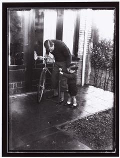 Jan van Pijnenburg met zijn zoon bij een fiets. Fotopersbureau Het Zuiden.