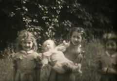 Still uit film D0094, twee meisjes met baby in de tuin.